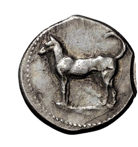 Ancient coin with a deer emblem on a white background