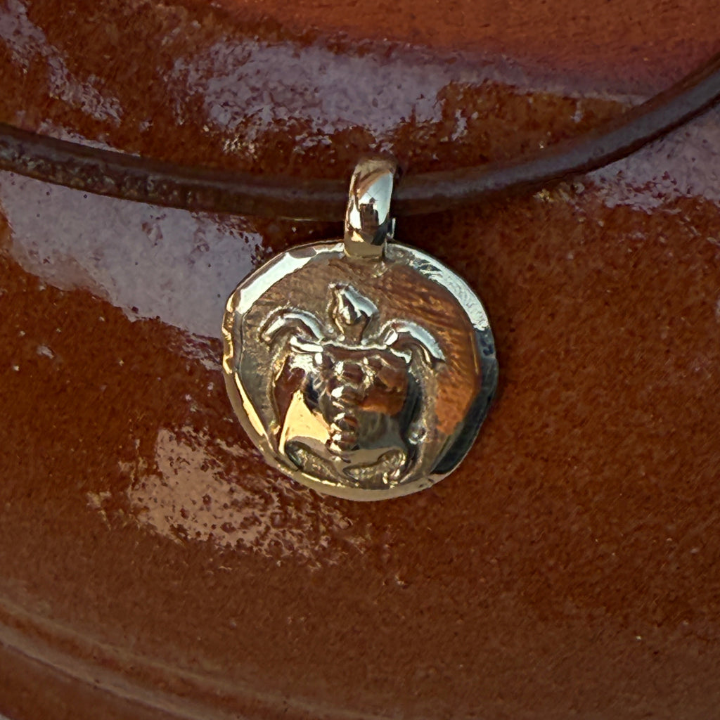 Gold pendant on a brown background