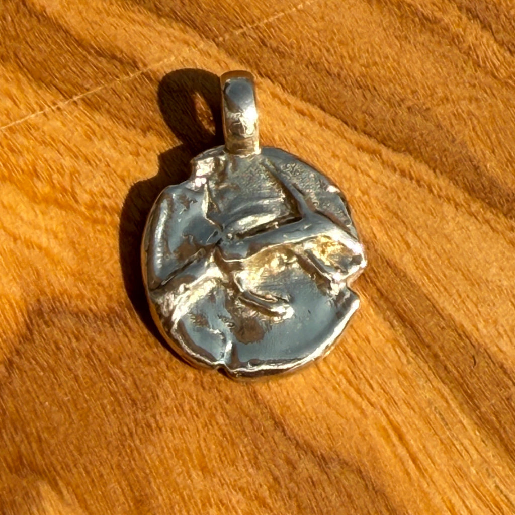 Silver pendant on a wooden surface