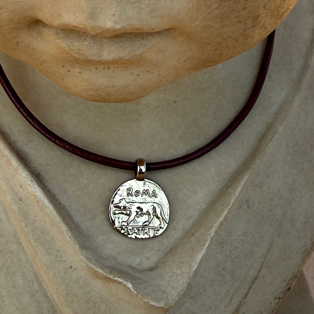 Statue wearing a necklace with a silver pendant featuring Roman design
