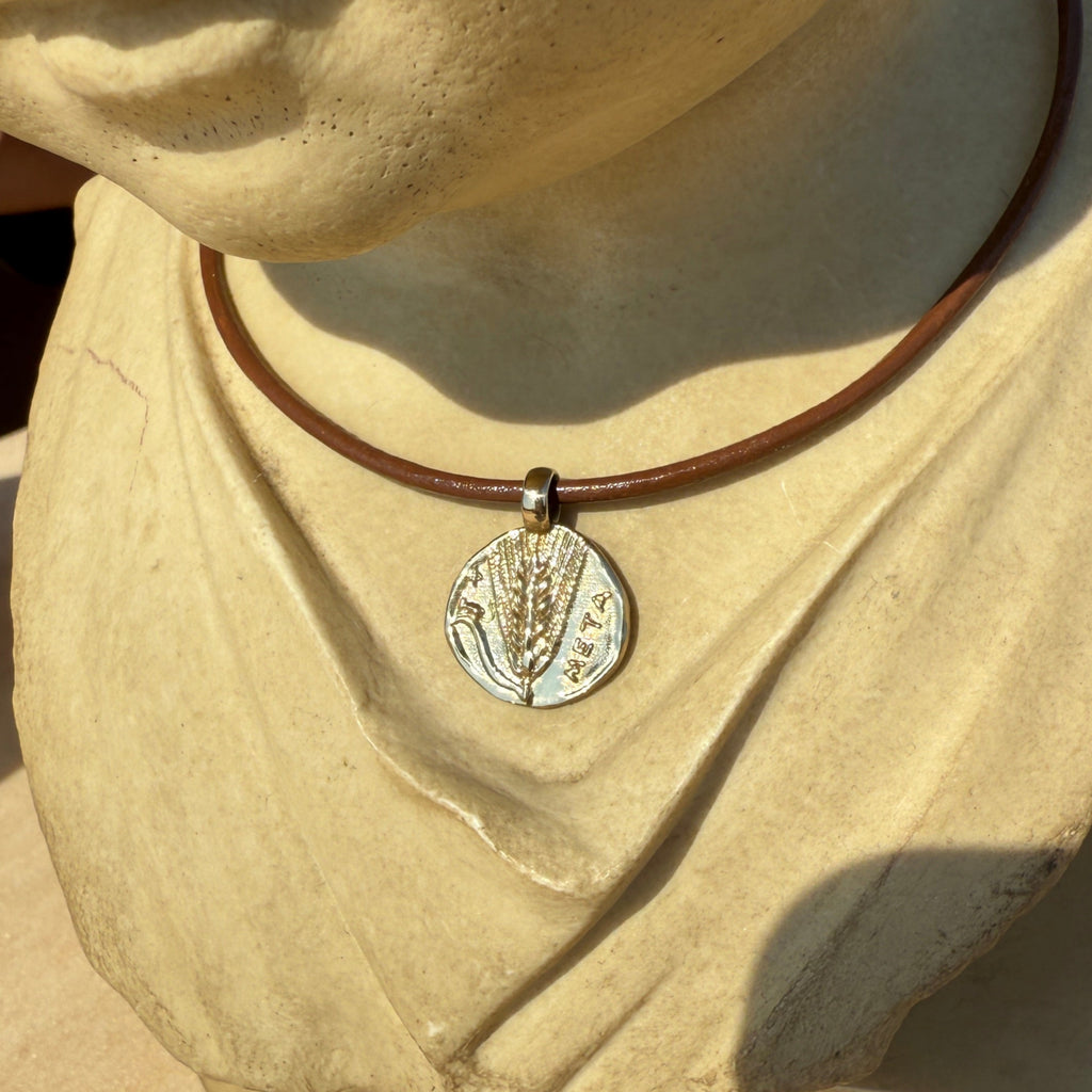 Close-up of a beige garment with a decorative button on a neutral background