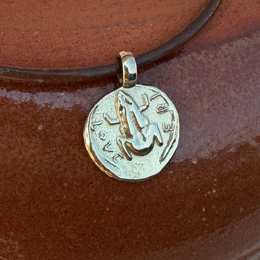 Silver pendant with 'In Love' engraving on a brown background