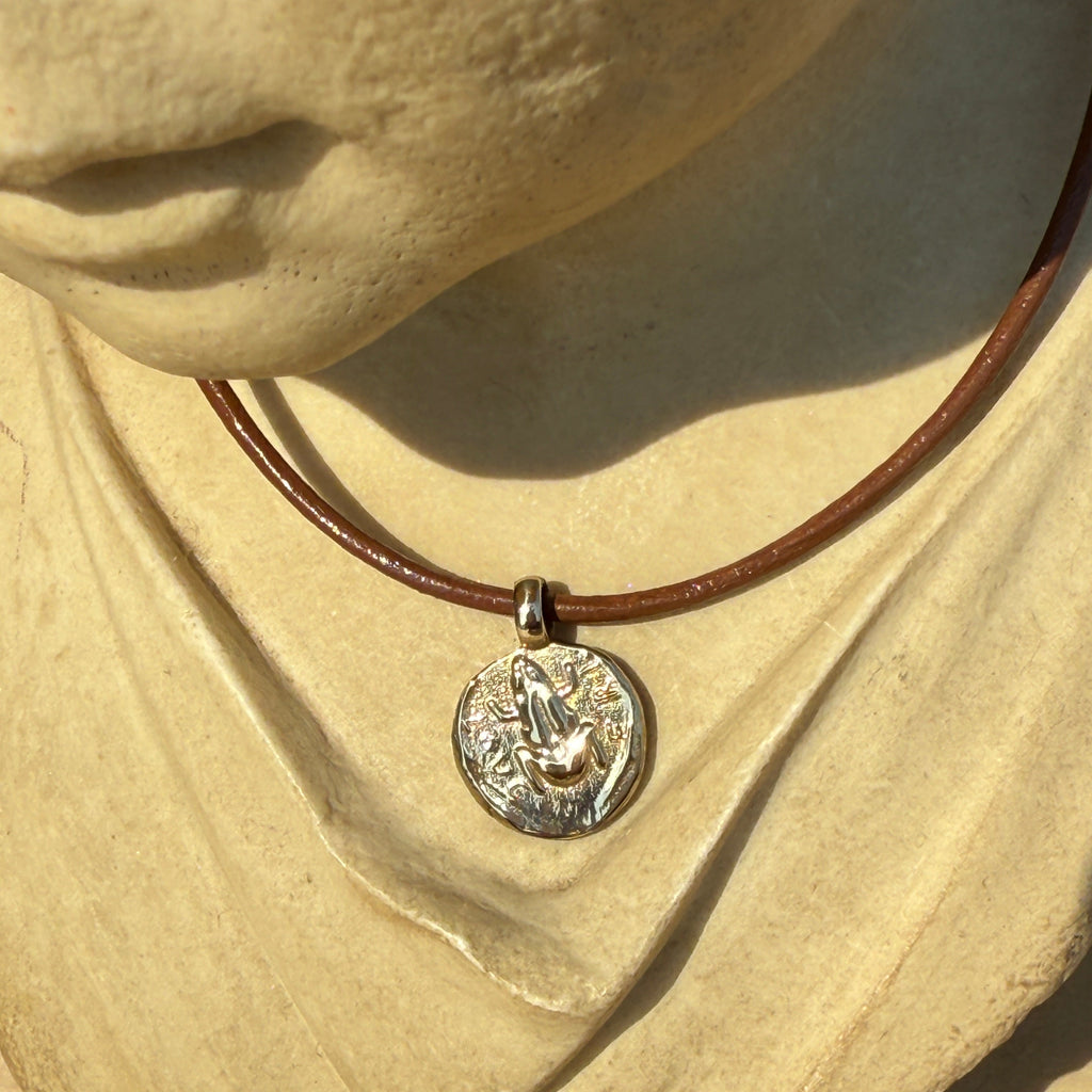 Necklace with a pendant on a textured beige surface