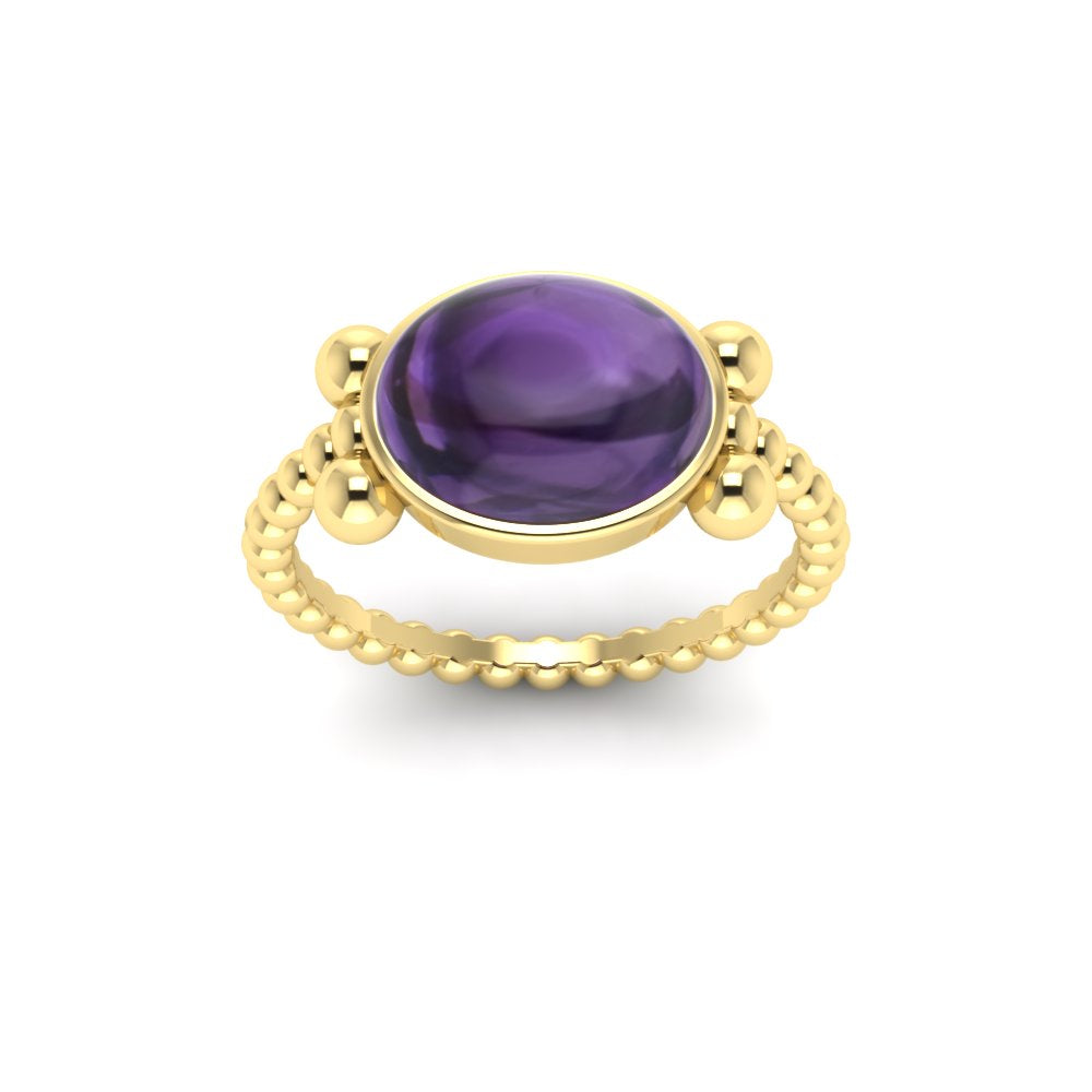 Gold or silver cabochon ring in a bezel setting. The stone is oval, and is framed by four balls. The shank is an incredible ribbed design.